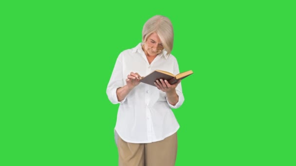 Mujer señora mayor leyendo libro viejo con gafas en una pantalla verde, Clave de croma. — Vídeos de Stock