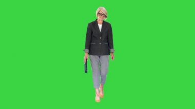 Yeşil Ekran 'da yürüyen takım elbiseli yaşlı, şık bir kadın, Chroma Key..