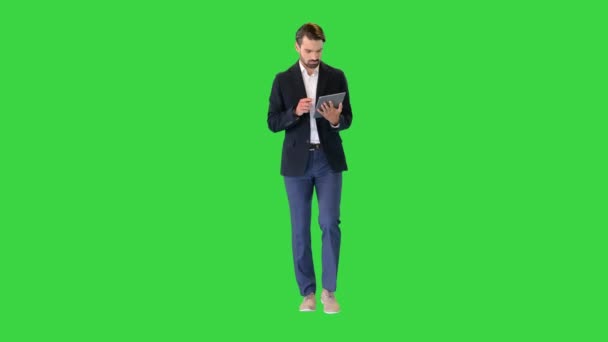 緑の画面、クロマキーでデジタルタブレットを扱う若いビジネスマン. — ストック動画