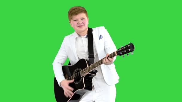 Junger Mann im weißen Anzug spielt Akustikgitarre auf einem Green Screen, Chroma Key. — Stockvideo