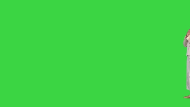 Mulher idosa bonita andando e pensando em tentar lembrar algo em uma tela verde, Chroma Key. — Vídeo de Stock