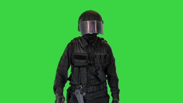 Terroristisch team bestrijder loopt met een pistool in een hand op een groen scherm, Chroma Key. — Stockvideo