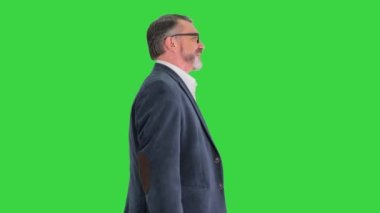 Kıdemli iş adamı yeşil ekranda alışveriş çantasıyla yürüyor, Chroma Key..