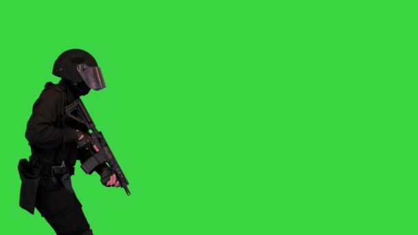 Полісмен у чорному камуфляжі ходить і стріляє з кулемета на зеленому екрані, Chroma Key. — стокове відео