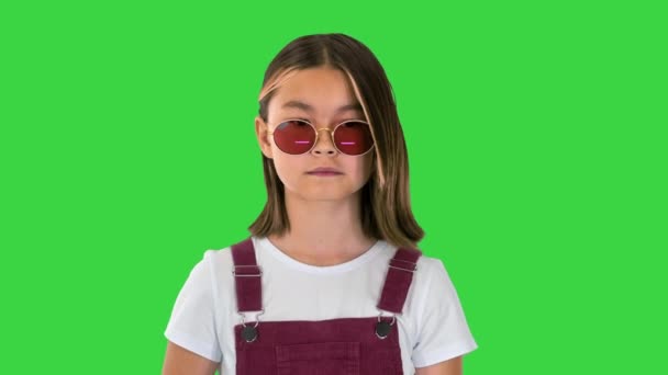 Ασιατικό παιδί με γυαλιά ηλίου περπατώντας σε μια πράσινη οθόνη, Chroma Key. — Αρχείο Βίντεο