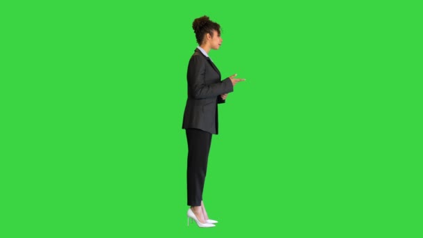 Joven mujer afroamericana en un traje explicando en cámara en una pantalla verde, Chroma Key. — Vídeos de Stock