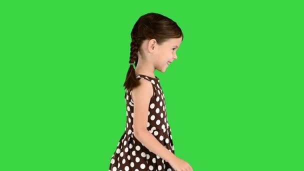 Sorrindo menina no vestido de bolinhas andando em uma tela verde, Chroma Key. — Vídeo de Stock