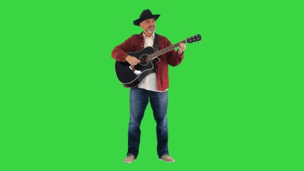 카우보이 모자를 쓰고 기타를 치며 그린 스크린, 크로마 키에서 노래하는 남자. — 비디오