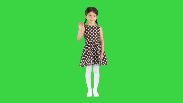 Красива брюнетка в сукні польської крапки махає до камери на зеленому екрані, Chroma Key. — стокове відео