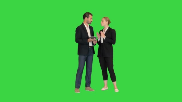 Schöne junge Geschäftsfrau und gutaussehender Geschäftsmann in formellen Anzügen verwenden ein digitales Tablet auf einem Green Screen, Chroma Key. — Stockvideo