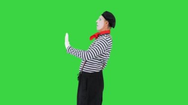 Pandomimci içeri giriyor, duvara bakıyor, kapıyı açıyor ve yeşil ekranda yürüyor, Chroma Key.