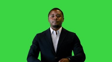 Siyah ceketli yakışıklı siyah adam gülümsüyor ve yeşil ekranı işaret ediyor, Chroma Key..