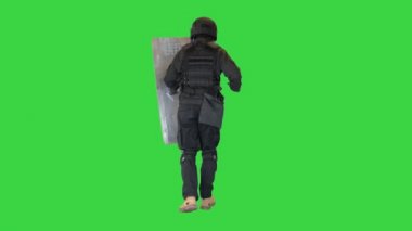 Çevik kuvvet polisi elinde bir kalkan ve sopayla Yeşil Ekran 'da koşuyor, Chroma Key.
