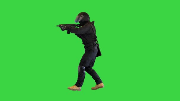 Maszkos fegyveres SWAT rendőr sétál és céloz puskával egy zöld képernyőn, Chroma Key. — Stock videók