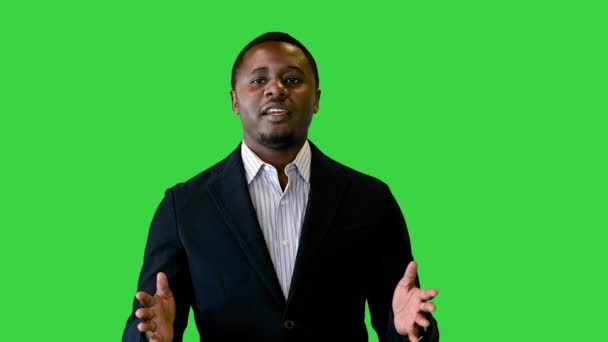 Afroamerykanin w czarnej kurtce rozmawiający przed kamerą na zielonym ekranie, Chroma Key. — Wideo stockowe