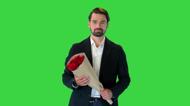 Man lopen en kijken naar horloge en het houden van bloemen op een groen scherm, Chroma Key. — Stockvideo