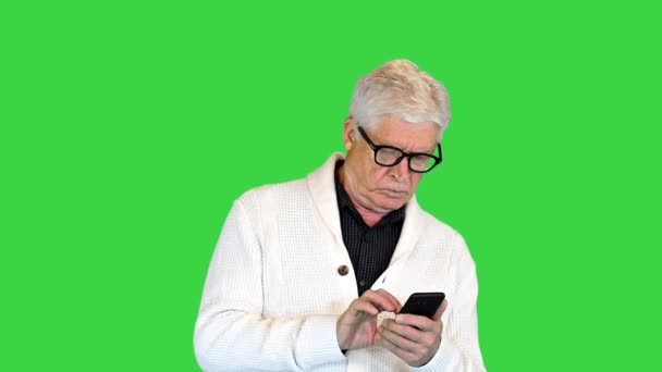 Senior homme mature textos au téléphone sur un écran vert, Chroma Key. — Video