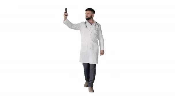 Læge tager en selfie med smartphone, mens du går på hvid baggrund. – Stock-video