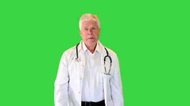 Steteskoplu kıdemli doktor yeşil ekranda yürüyor, Chroma Key..