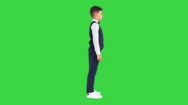 Papyonlu ve yelekli küçük çocuk Yeşil Ekran 'da konuşuyor, Chroma Key.