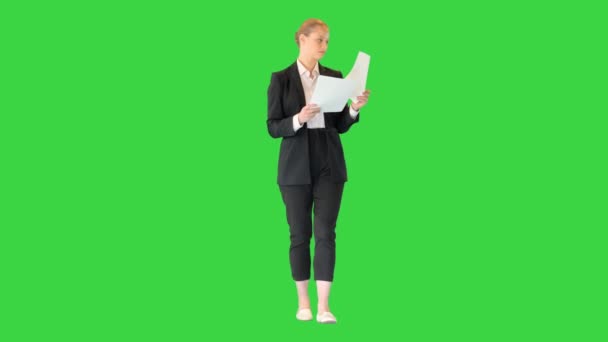 Giovane donna d'affari guardando attraverso i documenti mentre si cammina su uno schermo verde, Chroma Key. — Video Stock