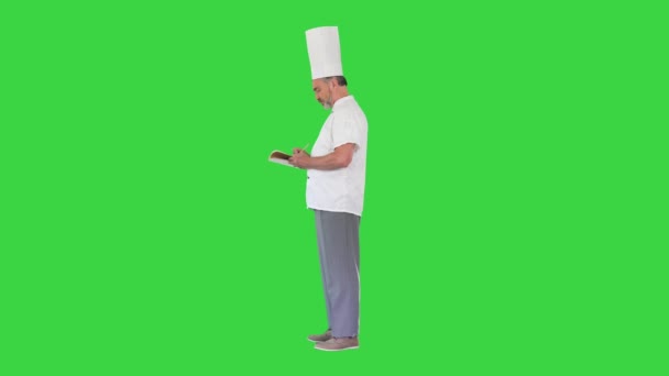 Male chef cook making notes on a Green Screen, Chroma Key. — Stock Video