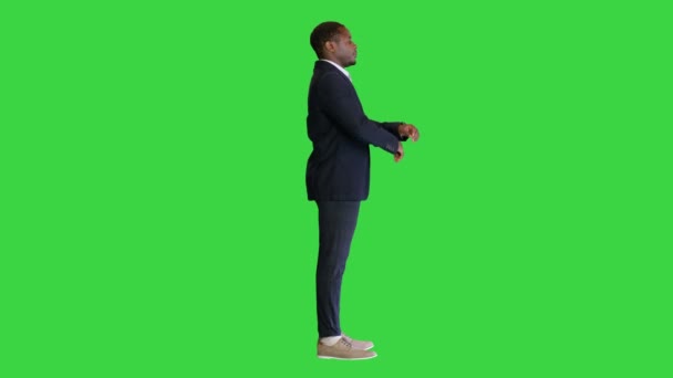 Fekete üzletember keresztbe tett karral mutogat egy zöld vászonra, Chroma Key. — Stock videók