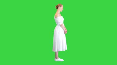 Beyaz elbiseli güzel kadın yeşil ekranda kameraya poz veriyor, Chroma Key.