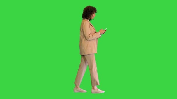 Jovem afro-americana senhora andando e mensagens de texto em uma tela verde, Chroma Key. — Vídeo de Stock