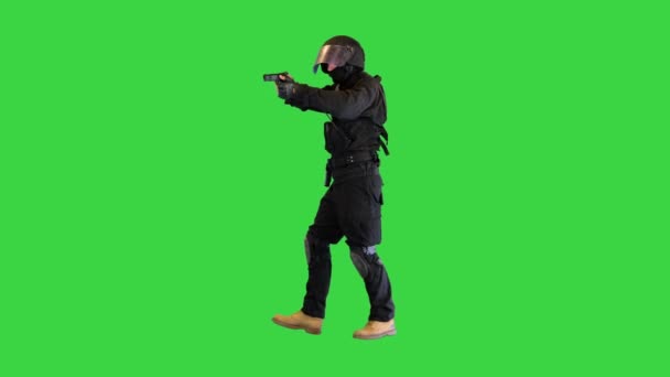 Fegyveres rendőr Céloz és lő egy pisztollyal, miközben sétál a zöld képernyőn, Chroma Key. — Stock videók