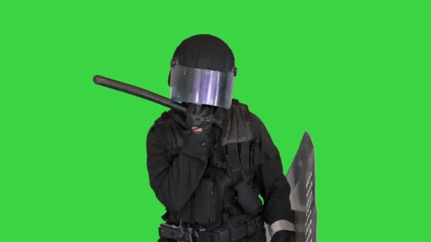 Bereitschaftspolizist mit taktischem Schlagstock und Schild, der auf einem Green Screen steht und sein Gesicht berührt, Chroma Key. — Stockvideo