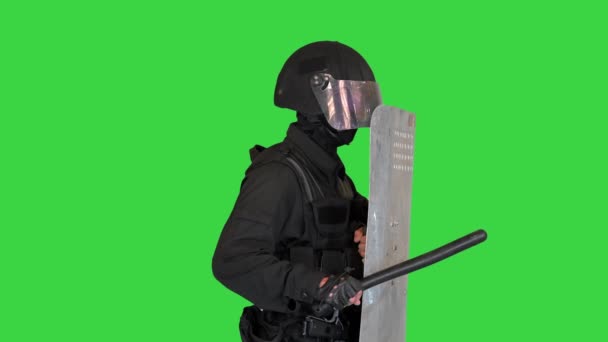 Policía con equipo completo para la cubierta de pie antidisturbios con una posición de retención de escudo en una pantalla verde, Chroma Key. — Vídeo de stock