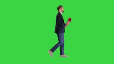 Yeşil ekranda kırmızı güllerle yürüyen zarif bir adam, Chroma Key.