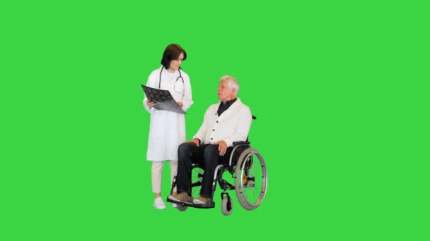 Νοσοκόμα που δείχνει εγκεφαλική μαγνητική τομογραφία σε ηλικιωμένο ανάπηρο ασθενή σε αναπηρική καρέκλα σε πράσινη οθόνη, Chroma Key. — Αρχείο Βίντεο