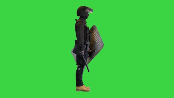 Special unit riot policeman with a shield and baton standing waiting on a Green Screen, Chroma Key. — Stock Video