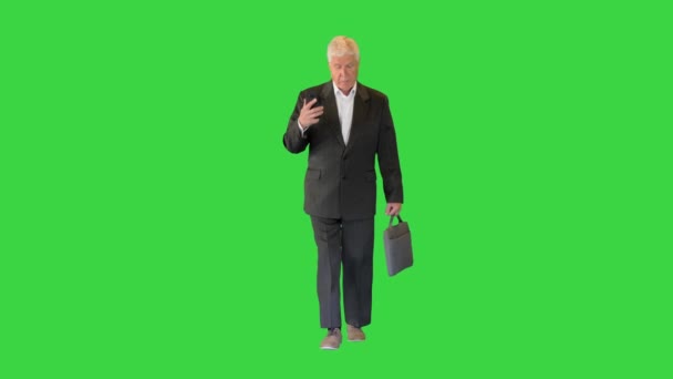 Senior affärsman promenader och ringa ett samtal på en grön skärm, Chroma Key. — Stockvideo