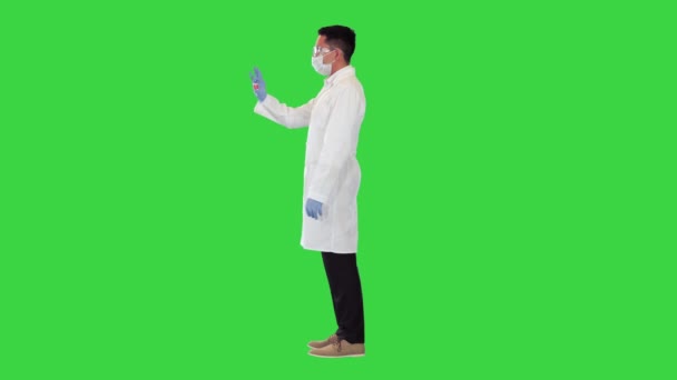 Doktor, yeşil ekrandaki bir ampulde kırmızı koronavirüs aşısına bakıyor.. — Stok video