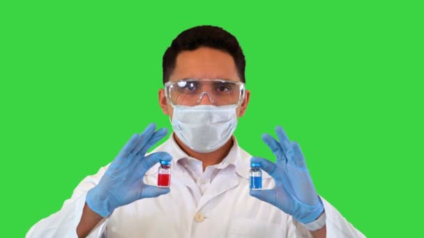Lékař ukazující v ruce dvě injekční lahvičky nebo ampulky Koncepce volby léčby na zelené obrazovce, Chroma Key. — Stock video
