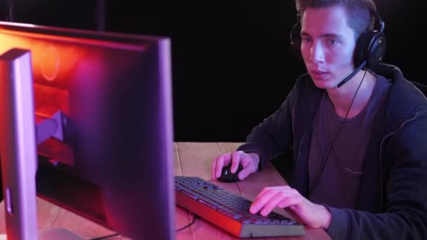 Streamer professionnel jouant à un jeu vidéo en ligne la nuit. — Video