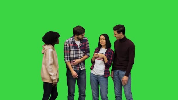 Группа молодых девушек и юношей, весело беседующих, смеющихся, улыбающихся, глядящих на зеленый экран, Chroma Key. — стоковое видео