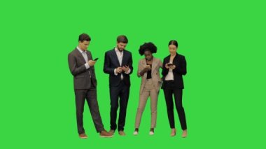 Resmi kıyafetli genç öğrenciler akıllı telefonlarıyla yeşil ekranda, Chroma Key 'de özümsendiler..
