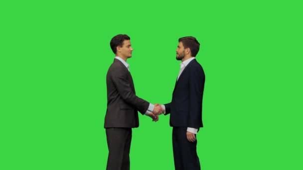 Dos jóvenes con trajes se saludan en una pantalla verde, Chroma Key. — Vídeos de Stock