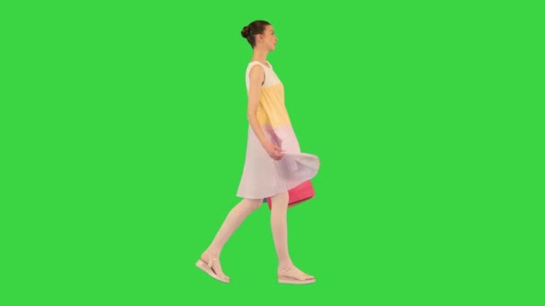 Tini lány egy nyári ruha séta bevásárló táskák a zöld képernyőn, Chroma Key. — Stock videók