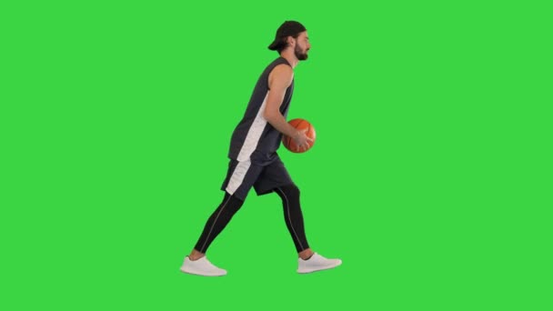 Joven jugador de baloncesto dribleando la pelota mientras camina en una pantalla verde, Chroma Key. — Vídeos de Stock