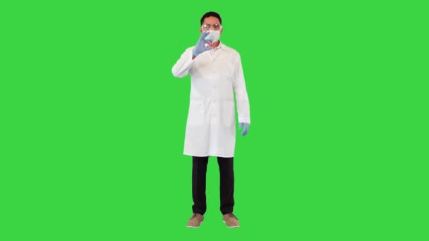 Γιατρός κατέχει ένα γυάλινο COVID-19 Coronavirus μπουκάλι εμβόλιο και γνέφει με έγκριση σε μια πράσινη οθόνη, Chroma Key. — Αρχείο Βίντεο