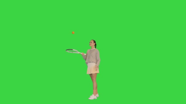 Молода жінка, яка кидає м "яч на своїй тенісній ракетці на зеленому екрані (Chroma Key).. — стокове відео