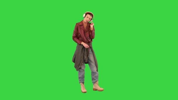 Cool rocker girl listening to music in headphones on a Green Screen, Chroma Key. — Stock Video