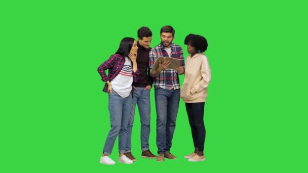 Четверо друзей проверяют информацию с помощью смартфона и обсуждают что-то на Зеленом экране, Chroma Key. — стоковое видео