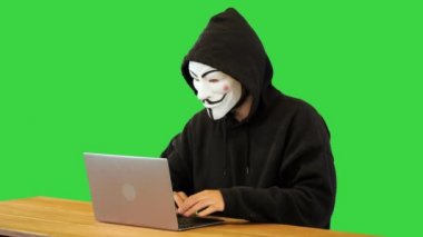 Vendetta maskeli bir bilgisayar korsanı Yeşil Ekran, Chroma Key üzerinde çalışıyor..