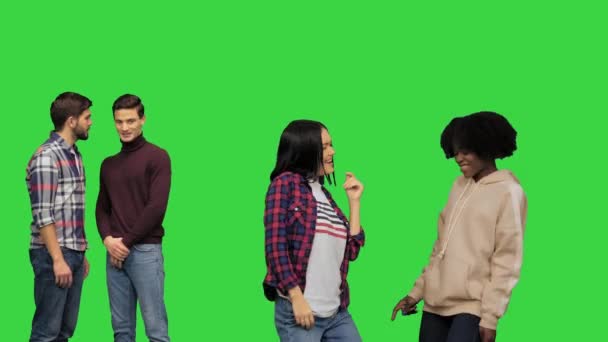 Два застенчивых парня смотрят, как красивые девушки танцуют на вечеринке, пытаясь подойти к ним на зеленом экране, Chroma Key. — стоковое видео